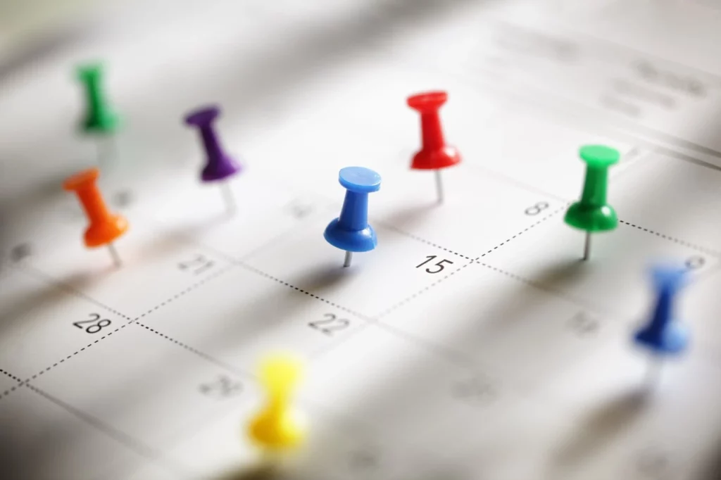 Photo d'un calendrier avec des punaises de colorées