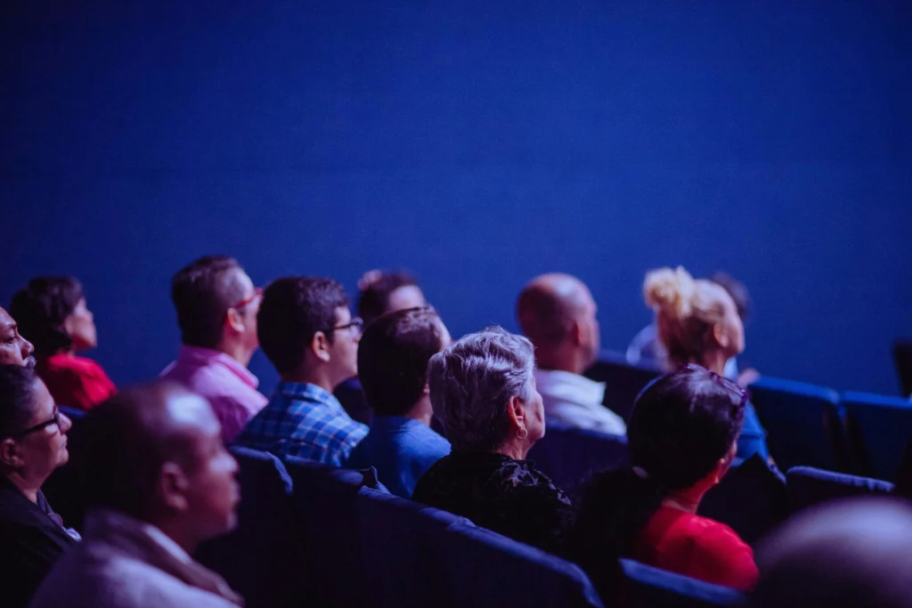 Photo de personnes dans l'attente d'un événement dans une salle sombre